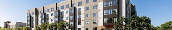 A modern apartment building with cars parked in front.