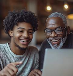 Two people are looking at a laptop screen together.