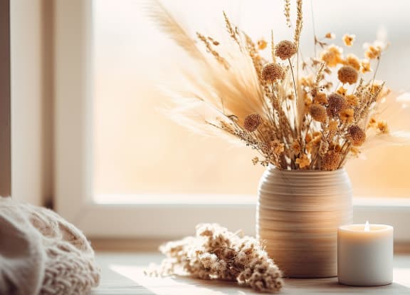 a vase with flowers and a candle on a window sill at Amity Senior, Amityville, NY 11701