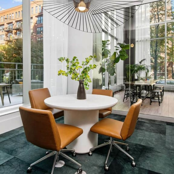 a dining area with a table and four chairs and a large window with a view of a