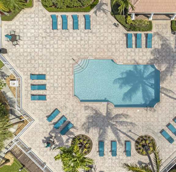 an overhead view of a swimming pool with umbrellas and chairs