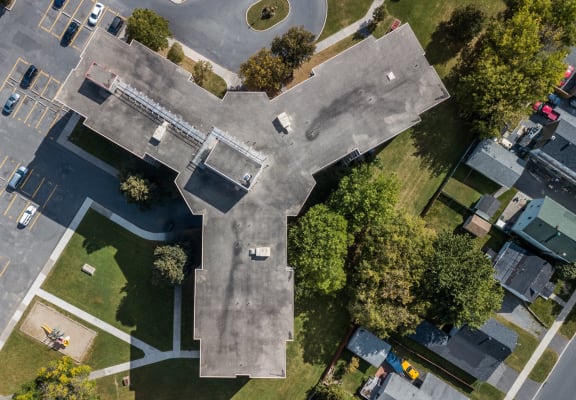 an aerial view of rooftops and trees on a city street