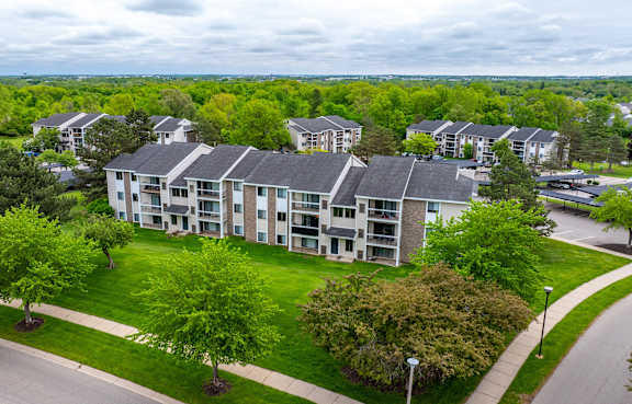 Apartment complex with green trees in front.