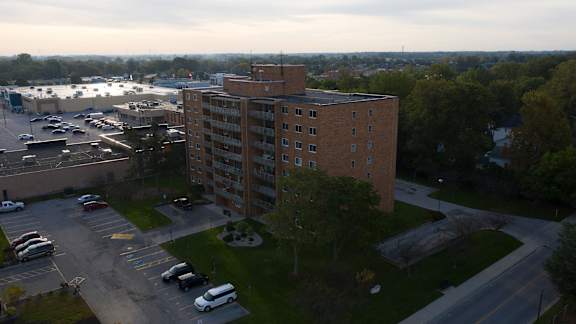 A parking lot with cars and a large building in the background.