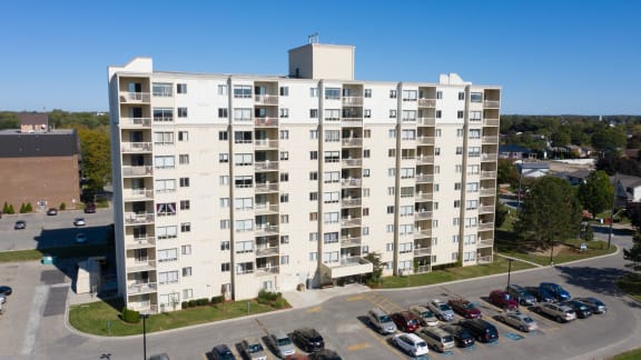 an aerial view of a large apartment building with cars in a parking lot