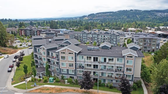 an aerial view of a large apartment building with a mountain in the background