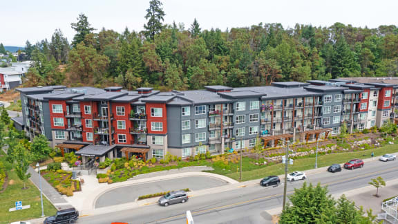 an aerial view of an apartment complex with trees in the background