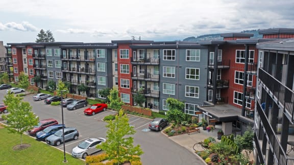 an aerial view of an apartment complex with cars parked in a parking lot