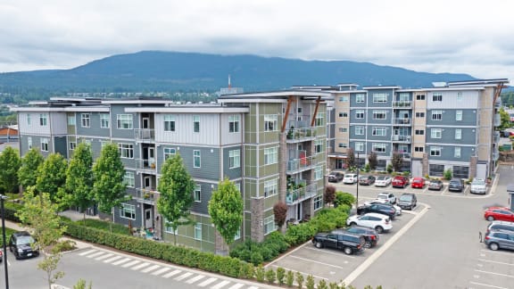 an aerial view of an apartment complex with cars parked in a parking lot