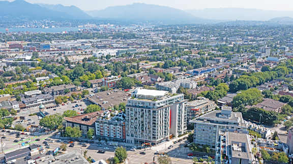 A cityscape with a large building in the center and mountains in the background.