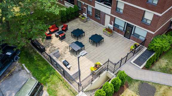 an aerial view of a patio in front of a brick building