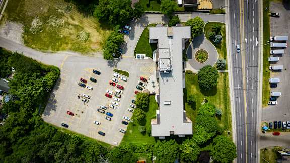 an aerial view of the parking lot of a building with cars parked