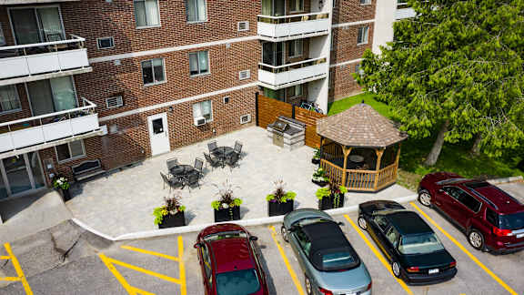 an aerial view of a parking lot in front of a brick building with parked cars
