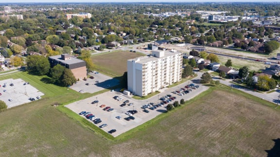 an aerial view of a parking lot and a white building