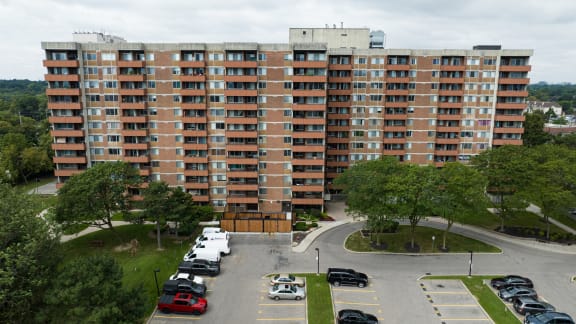 an aerial view of a large apartment building with cars parked in front