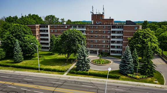 an aerial view of a building with trees in front of it