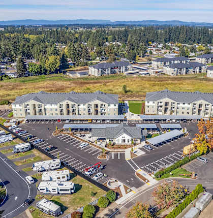 A large parking lot is surrounded by a mix of residential and commercial buildings.