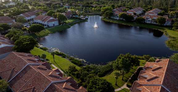 an aerial view of a lake with a sailboat in the middle of it