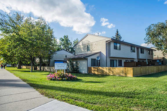 a white house with a yard and a sidewalk in front of it