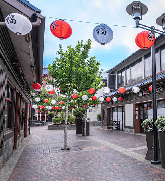 A street with red lanterns hanging from the ceiling.