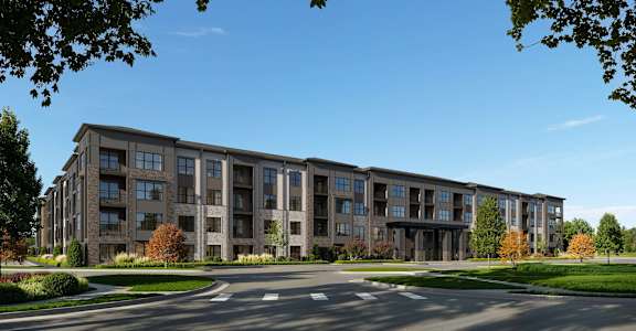 A large apartment complex with a parking lot in front.