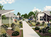 Thumbnail 2 of 6 - a neighborhood of manufactured homes with a sidewalk and landscaping