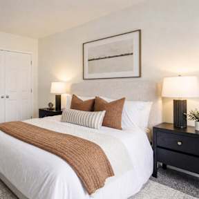 A bedroom with a large bed and a painting on the wall.