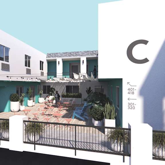 A white building with a balcony and a blue sky in the background.