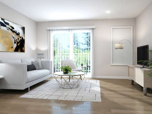 A living room with a white couch, a painting on the wall, and a potted plant.