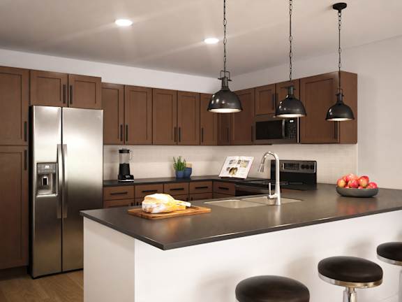 A modern kitchen with a refrigerator, sink, and bar stools.