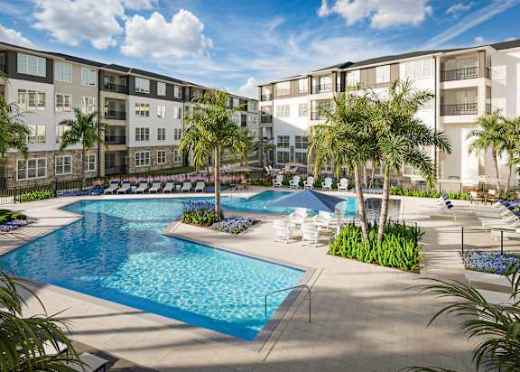 A large swimming pool surrounded by palm trees and lounge chairs.
