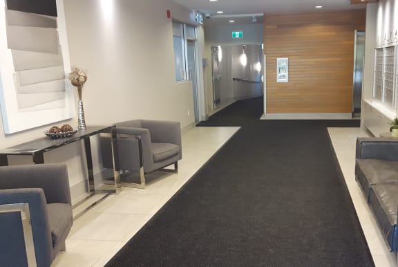 a lobby with couches and chairs and a hallway with a door