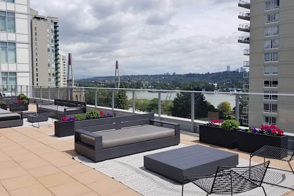 a roof top patio with furniture and a view of the city