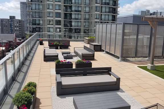 a roof top patio with couches and plants on a rooftop