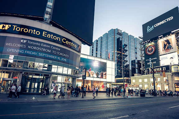 people crossing the street in front of the toronto eaton centre in the city