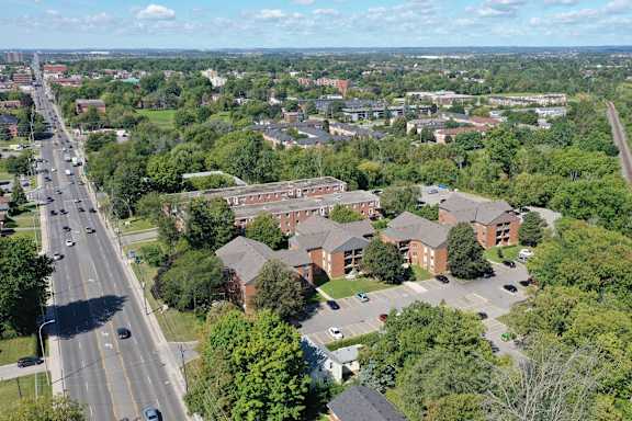 an aerial view of a neighborhood with cars on a road and buildings
