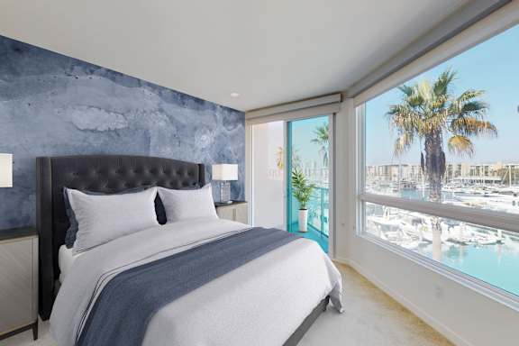 a bedroom with a bed and a window overlooking a body of water  at Esprit Apartments, Marina del Rey, CA
