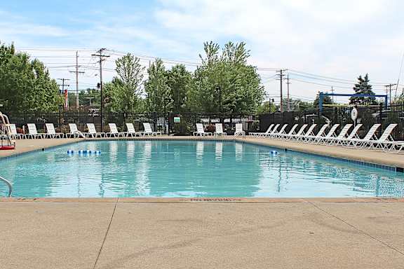 A large outdoor swimming pool with a slide and a flag.
