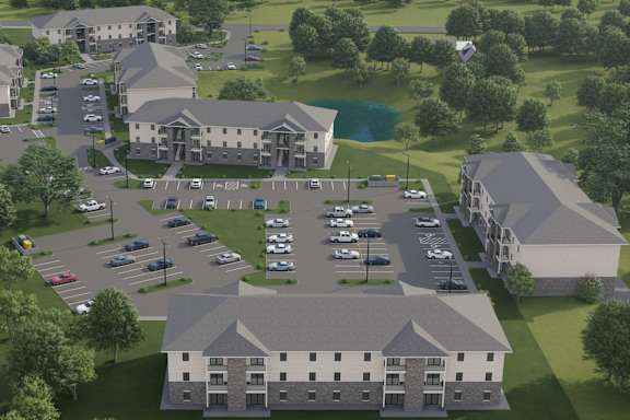 A rendering of a large building complex with a parking lot in front.