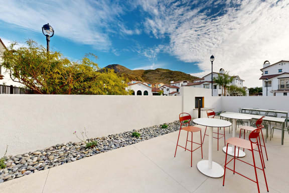 a patio with tables and chairs and a wall with mountains in the background at Anacapa Canyon, Camarillo, 93012