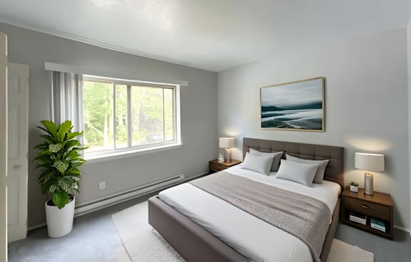 A bedroom with a large bed and a potted plant.