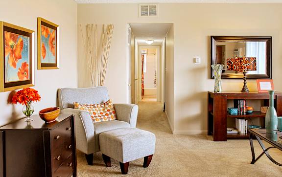 A living room with a grey chair and a brown cabinet.