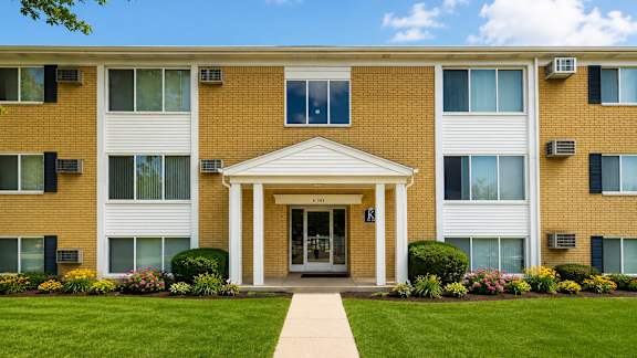 A building with a white entrance and a walkway leading to it.