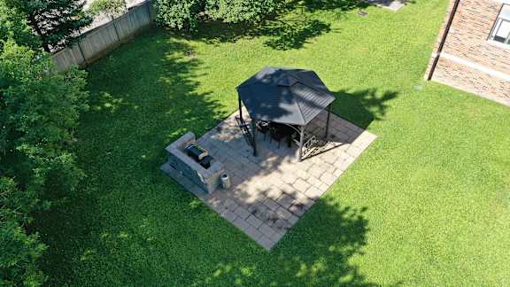 a backyard patio with a table and a grill