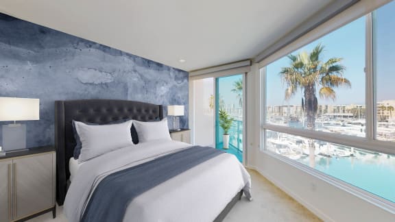 a bedroom with a bed and a window overlooking a body of water  at Esprit Apartments, Marina del Rey, CA