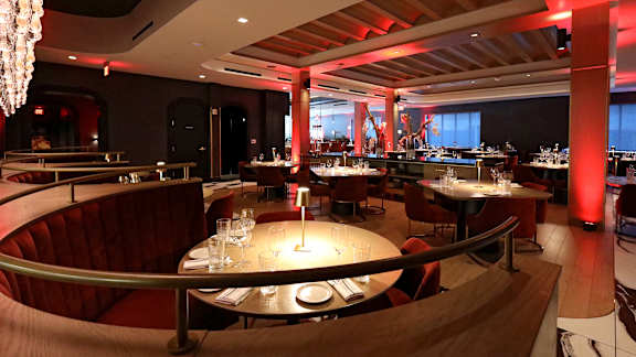 A restaurant with tables and chairs and a chandelier.
