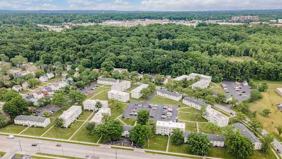 A large white building complex surrounded by trees.