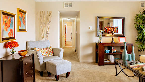 A living room with a grey chair and a brown cabinet.