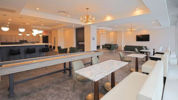 A large white room with a bar and a dining table.
