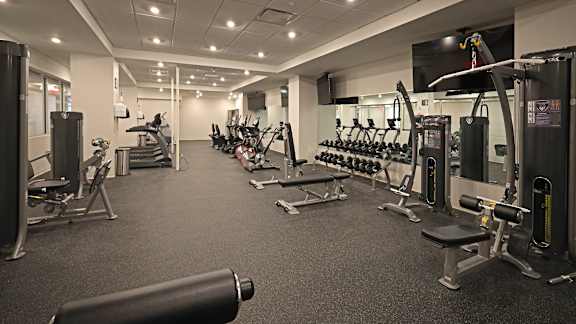 A gym with a variety of equipment including weights and machines.